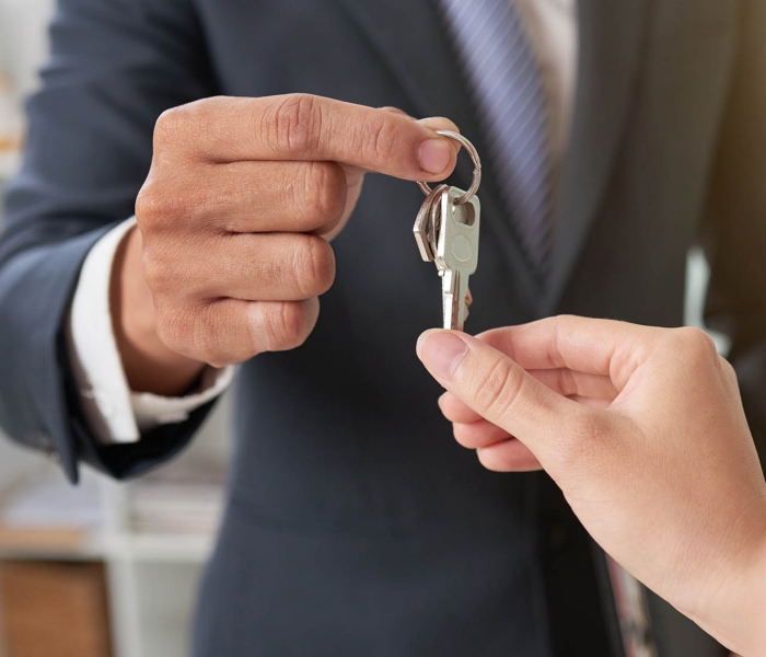 Hand of woman taking keys from hand of real estate owner